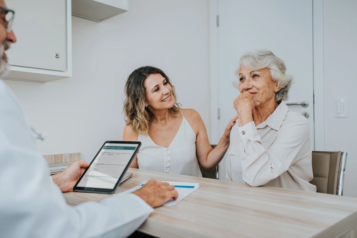 Doctor consulting warmly with a patient and her daughter