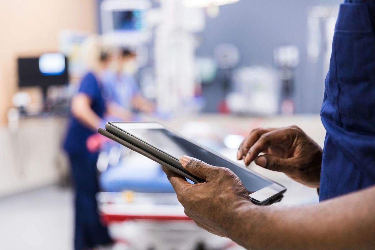 Hands using a medical tablet in a clinical setting