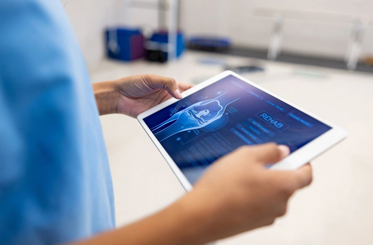 Clinician holding tablet with rehab application