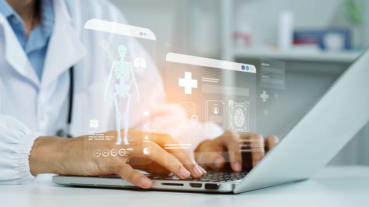 Doctor reviewing holographic patient data on laptop
