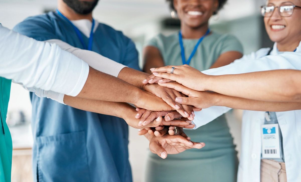 Healthcare team stacking hands in unity